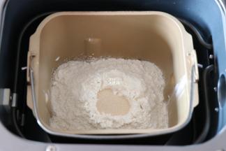 在面包粉中间挖个洞，加入干酵母粉；