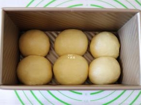 选择揉面程序揉面5分钟排气，然后分割成六等份一一揉圆，放入吐司模具中；