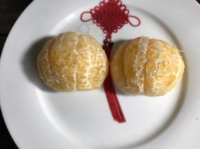 把剥下外皮的果肉分成两半，摆入盘中