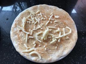 在饼皮上均匀的抹上一层番茄酱，撒一些芝士碎