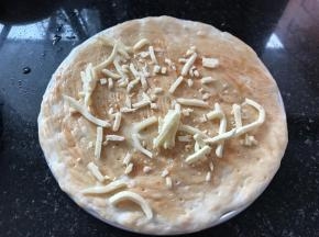 在饼皮上均匀的抹上一层番茄酱，撒一些芝士碎