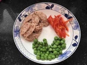 利用面团发酵的时间准备其它食材，红辣椒切丝，火腿切片，青豆放入沸水中过水20秒即可捞出