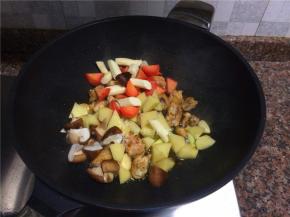 放入香菇、土豆、胡萝卜和山药翻炒30秒。