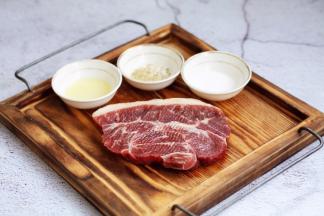 在板腱牛排两面撒上少许的海盐，盐放少了也没关系，吃的时候再撒些盐也可以，撒少许的黑胡椒碎，一点点就可以，黑胡椒碎一定要少，否则煎的时候糊了发苦，再在板腱牛排两面抹上少许的橄榄油，静置5分钟。