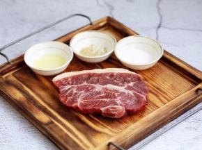 在板腱牛排两面撒上少许的海盐，盐放少了也没关系，吃的时候再撒些盐也可以，撒少许的黑胡椒碎，一点点就可以，黑胡椒碎一定要少，否则煎的时候糊了发苦，再在板腱牛排两面抹上少许的橄榄油，静置5分钟。