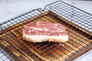 解冻后，用厨房用纸吸干板腱牛排多余的水分。