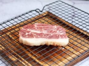 解冻后，用厨房用纸吸干板腱牛排多余的水分。