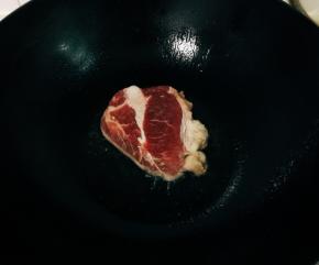 提前开水烫一下盘子。锅烧冒青烟，放入一勺橄榄油，放入牛排煎两分钟