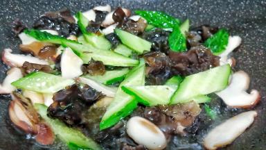 留一点油放蒜泥炒香，再下香菇、黑木耳翻炒片刻，下黄瓜片翻炒。