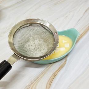 打匀的蛋液过筛的倒入到放有豆腐的容器中