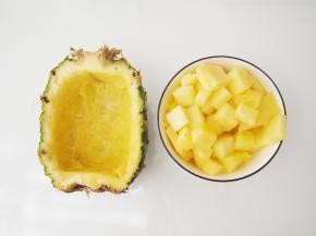 等待蒸米饭的时候，准备其他食材。将菠萝果肉挖出来，切成丁