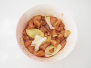 将鸡胸肉切成小丁放入大碗中，放入生姜片、葱段、料酒、生抽、盐、细砂糖和1小勺花生油抓匀，腌制20分钟