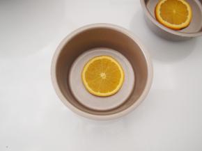 切一片橙子放在不粘模具底部，如果用的是普通模具，需要刷一层油防粘。