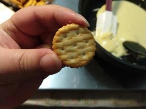拿一块小饼干，用小勺子或者你觉得方便的工具，挑一点牛轧糖放饼干上。