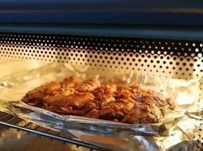 烤盘包一层锡纸，烤架包2层锡纸。烤箱选择烹饪烤功能，200℃，时间30分钟，烤箱自动预热。烤盘放入烤箱底部防漏，将鸡翅一个个均匀摆在烤架上，淋上酱汁，放在烤箱中上层，关闭烤箱开始烤制。