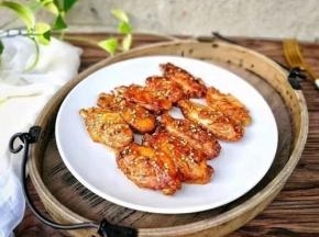 烘烤15分钟左右后，取出烤架将每个鸡翅翻面，继续送入烤箱烤，直到滴声后提示结束。最后撒上熟白芝麻就可以开吃啦～