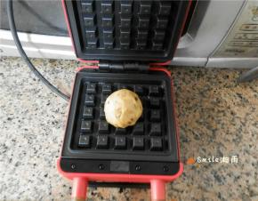 华夫饼模具上刷油，预热后放上一个面团。