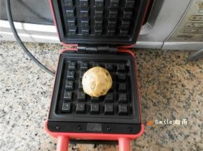 华夫饼模具上刷油，预热后放上一个面团。