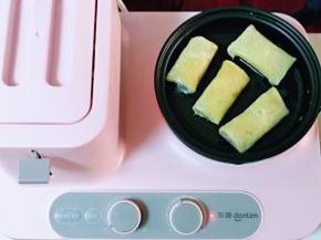 再把包好的春卷皮摆放在平底锅中。