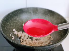 待肉糜炒变色后加入料酒，翻炒均匀。