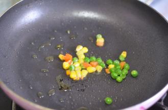 起锅烧油，倒入混合蔬菜粒。