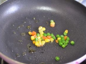 起锅烧油，倒入混合蔬菜粒。