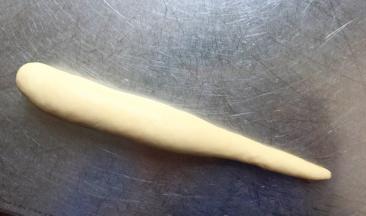 从一边卷起，卷成一头粗一头洗的条