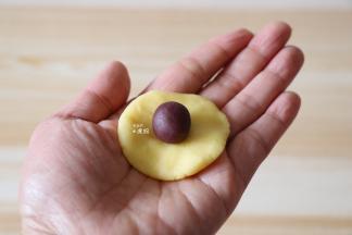 取一个面团压扁，包入馅料；