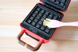 早餐机预热好后，上下烤盘都刷一层黄油；