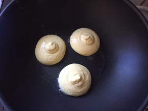 装入裱花袋挤入不粘锅中，也可以用勺子，周围用小勺子滴两小勺水，盖上锅盖小火煎3到5分钟，看厚度