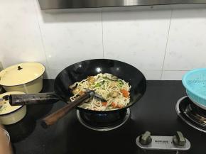 加入面条，继续翻炒。加入辣椒和姜蒜，放好调味料。