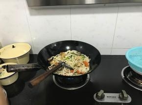 加入面条，继续翻炒。加入辣椒和姜蒜，放好调味料。
