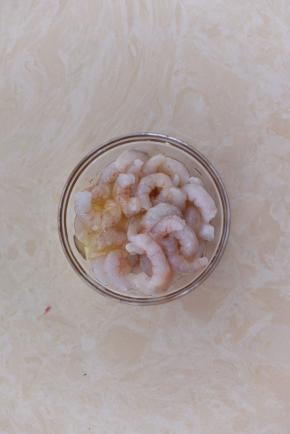 鲜虾剪去头部，剥去外壳后洗净，打入一个蛋清。