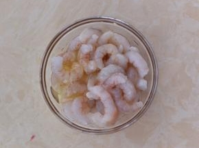 鲜虾剪去头部，剥去外壳后洗净，打入一个蛋清。