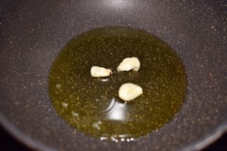 锅烧热，倒入油，油温升高后放入蒜瓣爆香