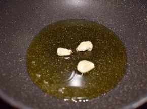 锅烧热，倒入油，油温升高后放入蒜瓣爆香