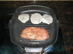 放入牛扒和鱼饼，煎熟一面再翻面。