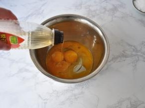 在蛋黄加入白砂糖、牛奶、玉米油搅拌均匀。