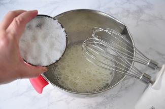 在蛋白中加入柠檬汁或白醋，用电动打蛋器中速搅拌，待蛋白打至鱼眼泡状态时，加入三分之一的的糖。