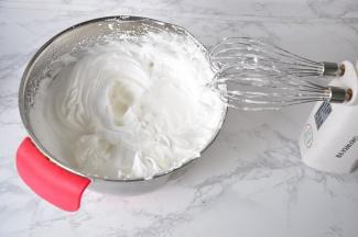 接着在蛋白变细腻时，有纹路时分别加入砂糖，搅打至干性发泡。以提起打蛋器有挺立的小尖角为准。这时，开始预热烤箱，我用的是135度。