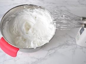 接着在蛋白变细腻时，有纹路时分别加入砂糖，搅打至干性发泡。以提起打蛋器有挺立的小尖角为准。这时，开始预热烤箱，我用的是135度。