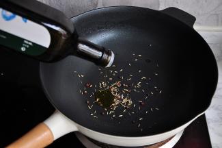 先将花椒和小茴香籽放在锅中，然后倒入橄榄油，开小火炒香。