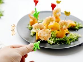 再把虾和芒果穿在一起，摆在盘子上。底部用切碎的苦菊做点缀即可。美美的享用吧！