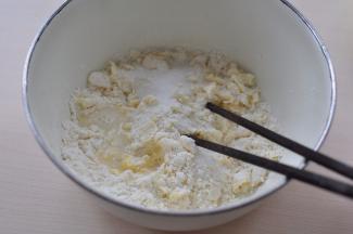 油皮材料高筋面粉、白砂糖、黄油放入盆中，一点点加入开水，揉成光滑的面团。