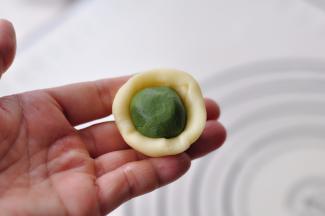 取一份油皮，按扁后放入一份油酥。