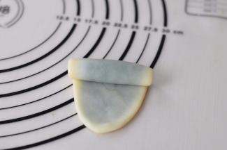 整个全部包完后取最开始包好的那份，依次擀开成椭圆片，自上而下卷起来。