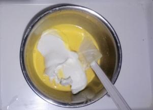 取三分之一蛋白加入蛋黄糊中用刮刀翻拌切拌均匀，不可画圈搅拌