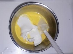 取三分之一蛋白加入蛋黄糊中用刮刀翻拌切拌均匀，不可画圈搅拌