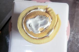 把蛋糕卷竖放在蛋糕盒底部