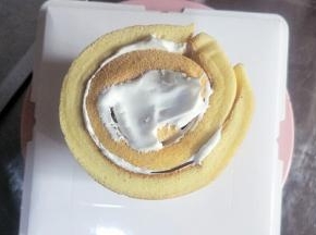 把蛋糕卷竖放在蛋糕盒底部